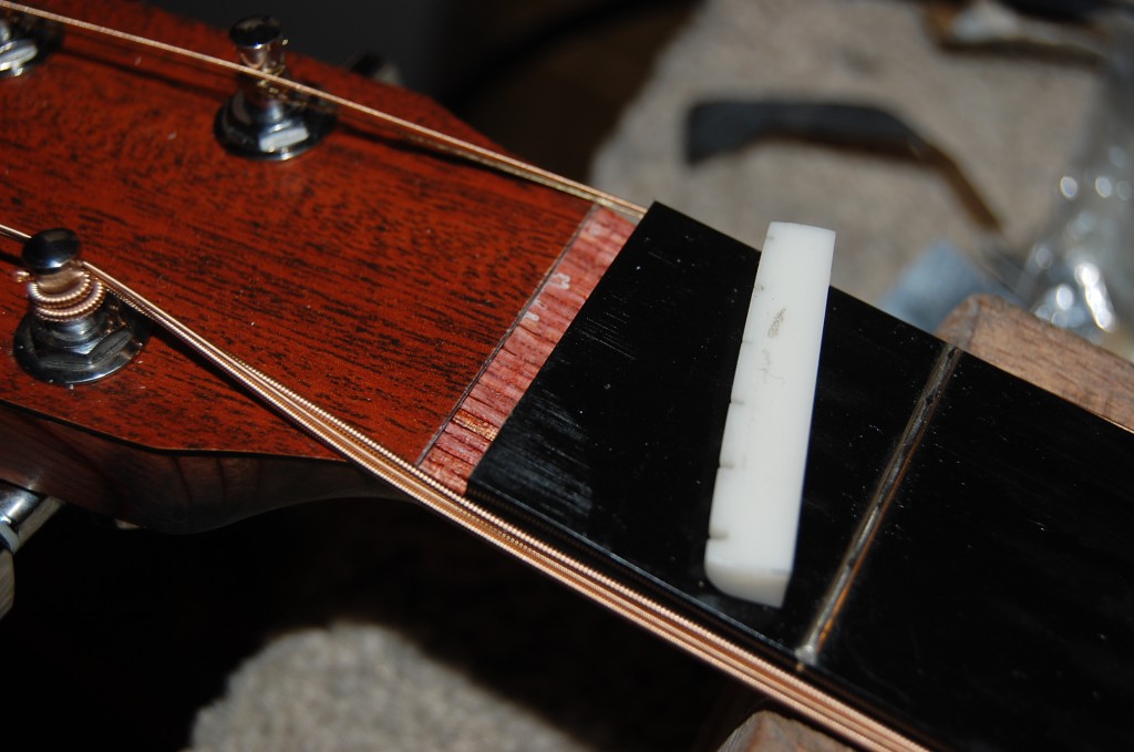 Nut had previosuly been cut too low and open chords rattles on the first fret